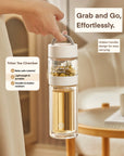 Clear tea infuser bottle with white handle held by a hand, set against a neutral background.