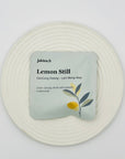 Lemon Still DanCong Oolong tea bag on a white textured plate, featuring soft botanical illustration and clean lemony aesthetic.