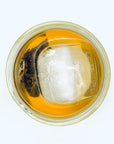 Top view of Moonlit Magnolia DanCong Oolong cold brew with tea bag and ice floating in a clear glass, highlighting the elegant Magnolia fragrance.