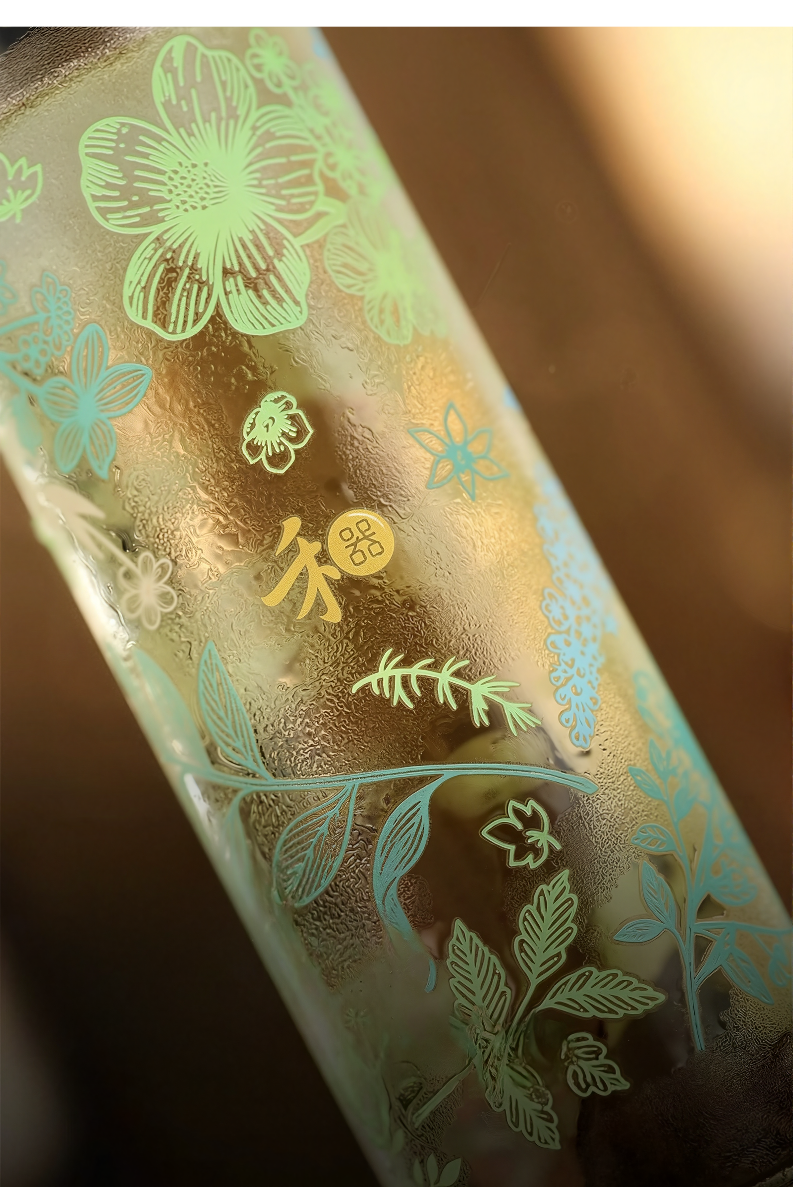 Glass bottle with floral etching on a blurred background