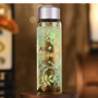 Decorative glass bottle with floral patterns on a wooden surface