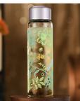 Decorative glass bottle with floral patterns on a wooden surface