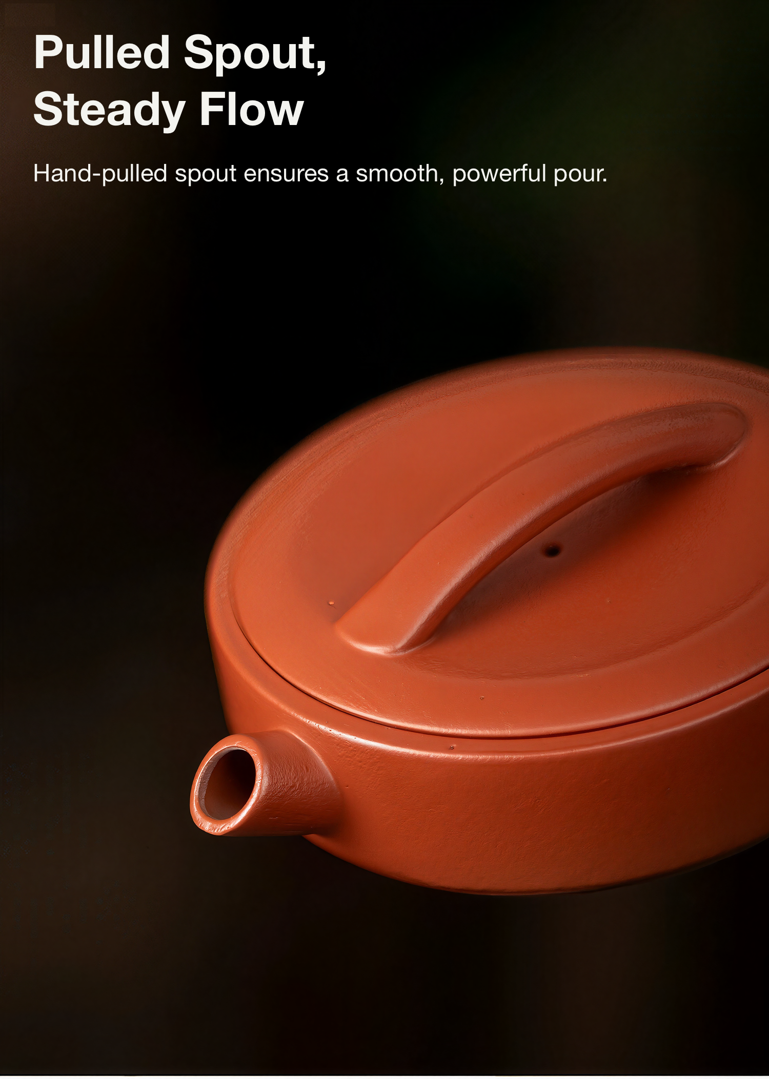 Red ceramic teapot with a pulled spout on a dark background