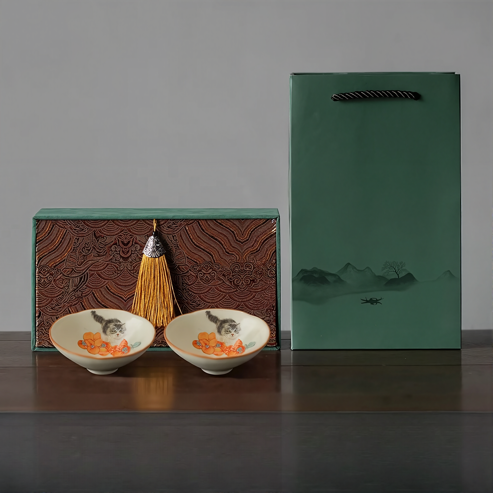 Gift set of two Persimmon Cat Douli Teacups with hand-painted kitten and persimmon design, displayed with decorative box and green gift bag