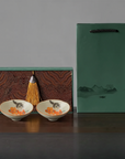 Gift set of two Persimmon Cat Douli Teacups with hand-painted kitten and persimmon design, displayed with decorative box and green gift bag