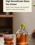 Glass tea infuser with tea in a mug on a wooden surface, text about high borosilicate glass.