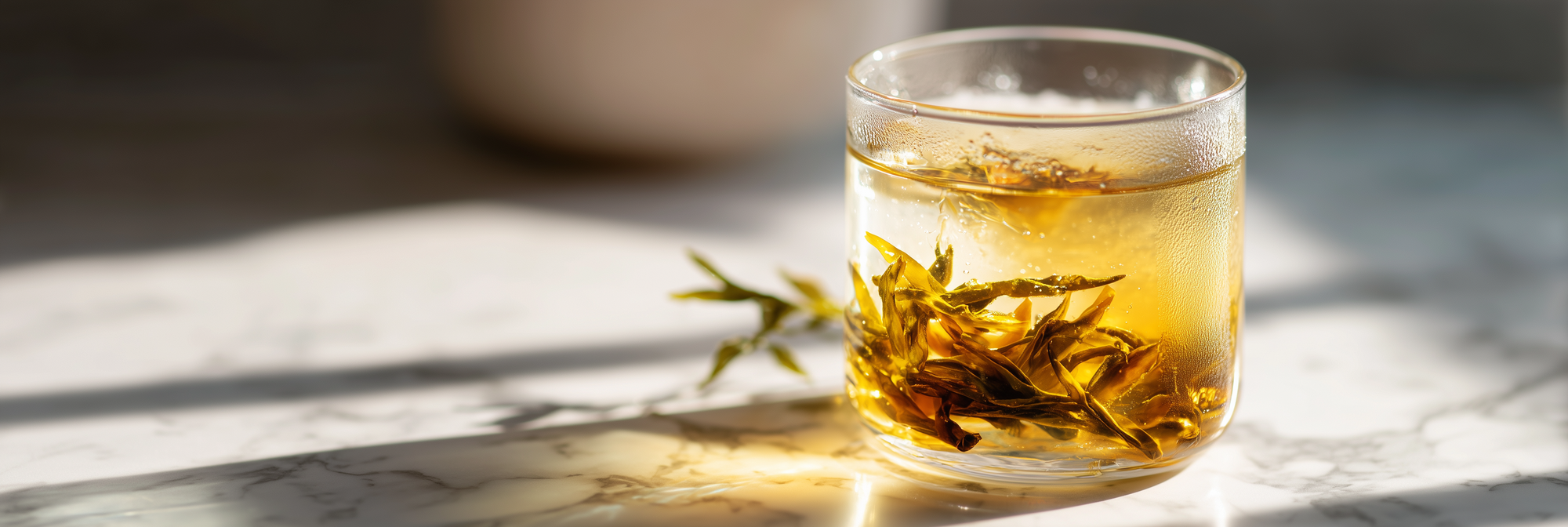 Glass of tea with tea leaves on a marble surface